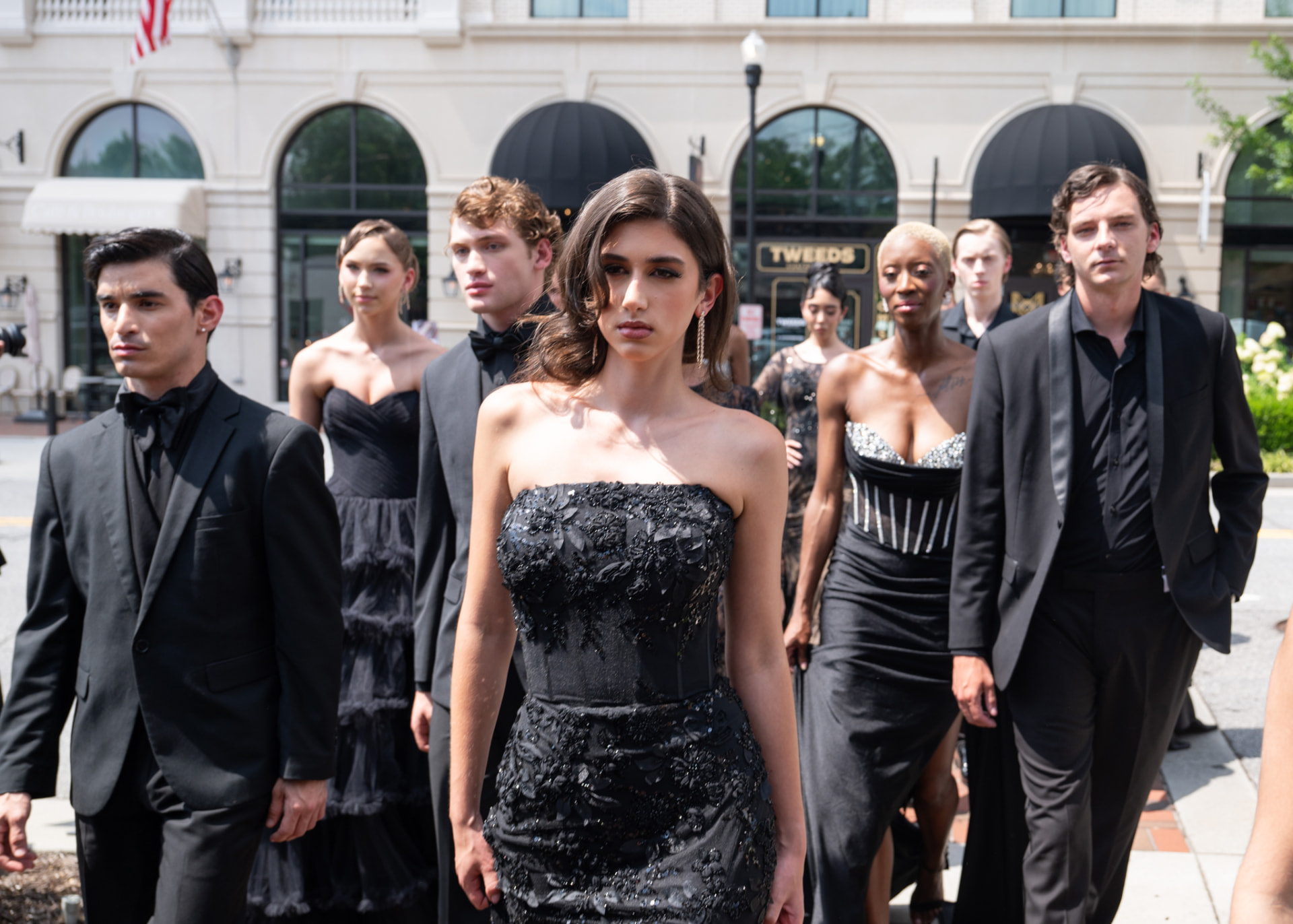 Close crop of the lead model in a beaded black gown mid-walk