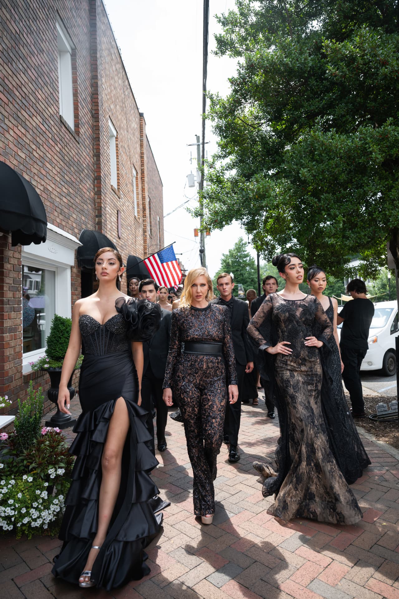 Models in black lace and satin walking a brick sidewalk
