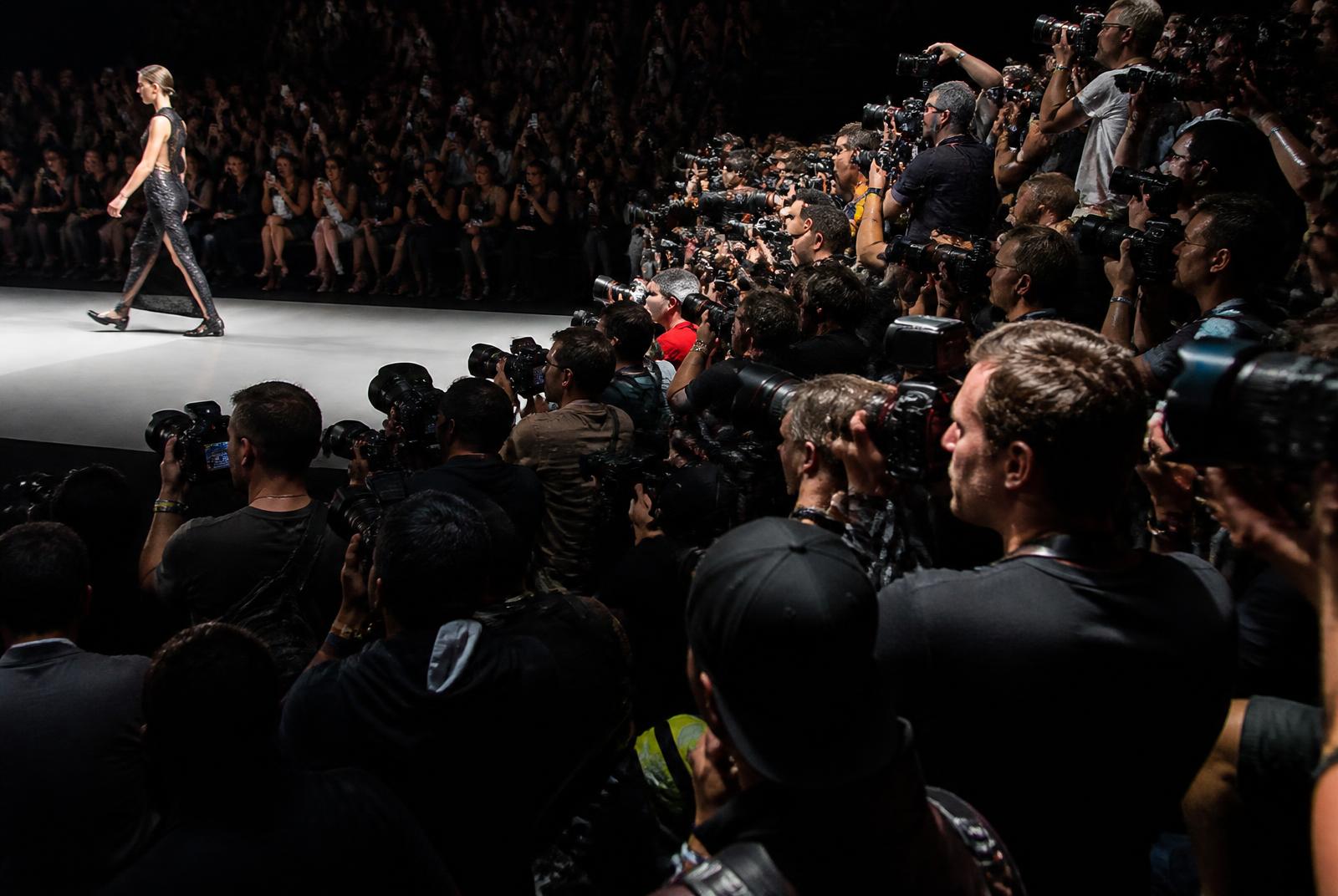 Photographers and press shooting a model on the runway